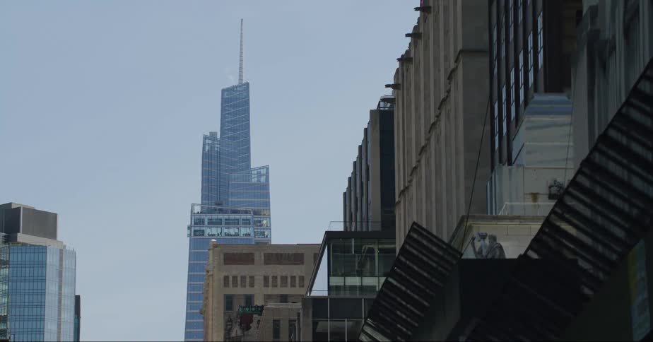 Vapor rises near building on street leading to tall skyscraper