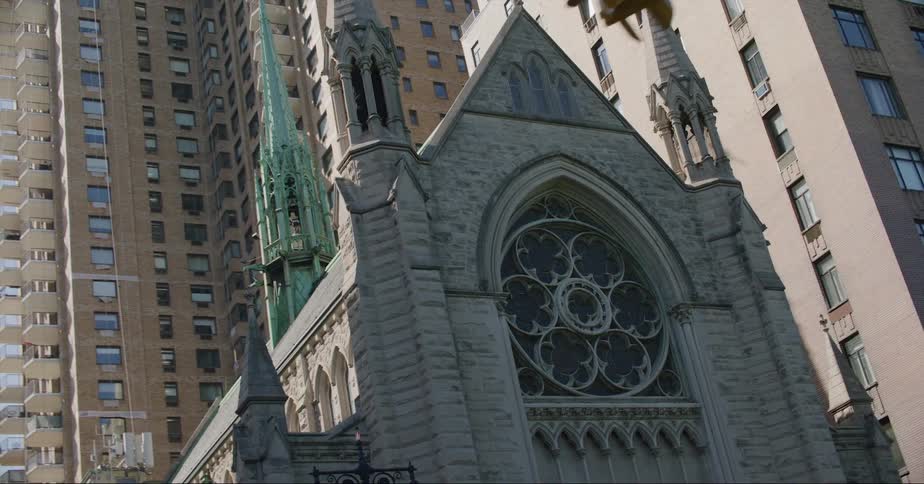 Exterior view of church next to tall apartment buildings in the city