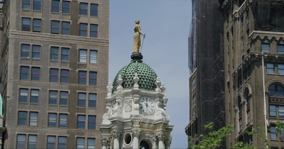 Golden sculpture atop a clock tower in the city