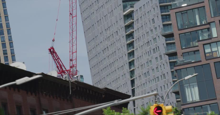 Construction crane works on skyscraper in downtown