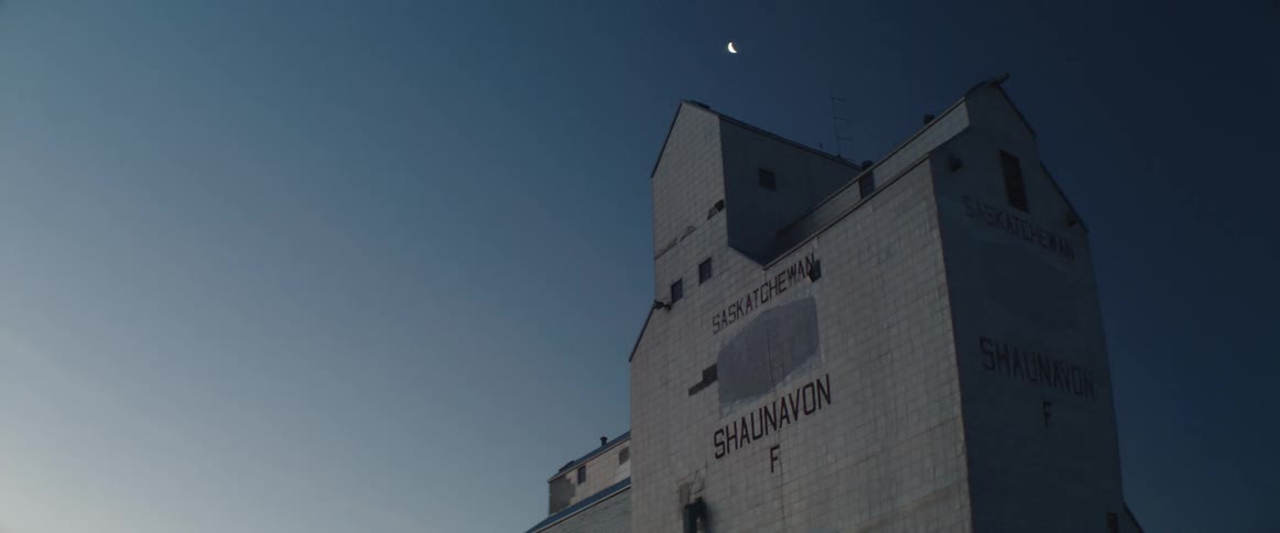 Night turns to day over grain tower in countryside