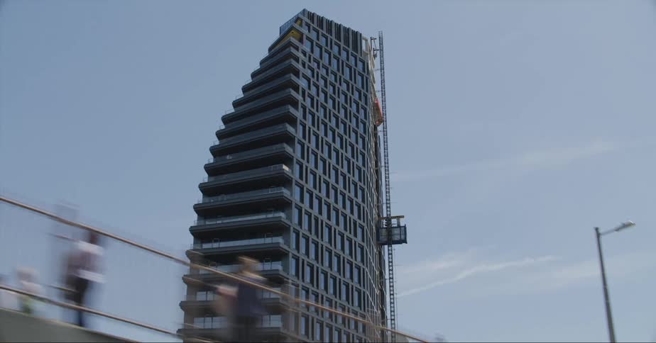 A tall building with unique architecture can be seen standing prominently amidst an urban area