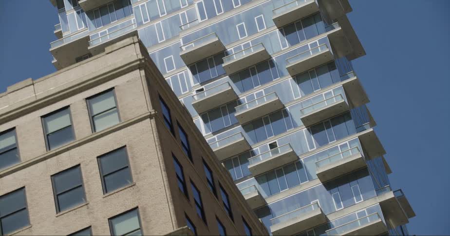 Exterior view of apartment building with balconies against blue sky