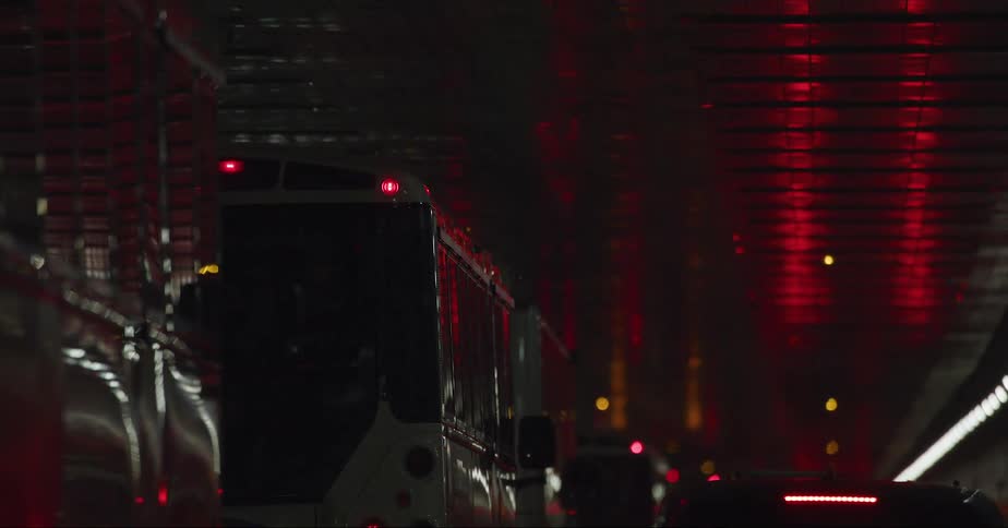Trucks and buses driving in traffic inside a tunnel