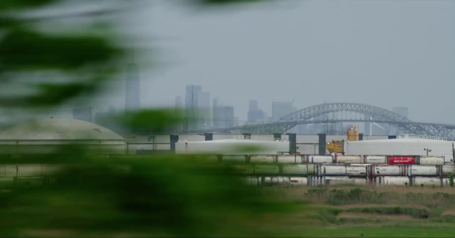 Shipping containers and warehouses in front of a city skyline