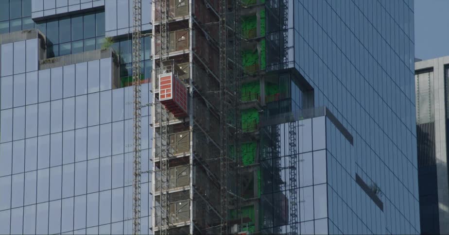 Construction elevator climbing the facade of a tall skyscraper