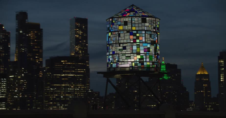 Tom fruins water tower in front of new york city skyline at evening