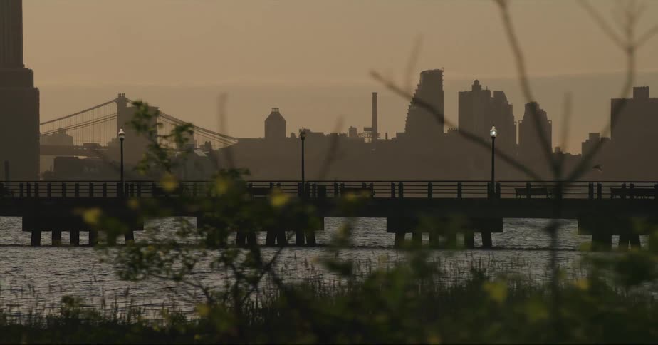 Bridge over a river next to the city skyline at evening