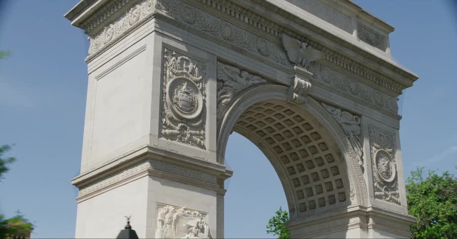 People walk around plaza in new york city near washington square arch