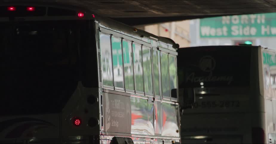 Busses and cars drive through tunnel on highway