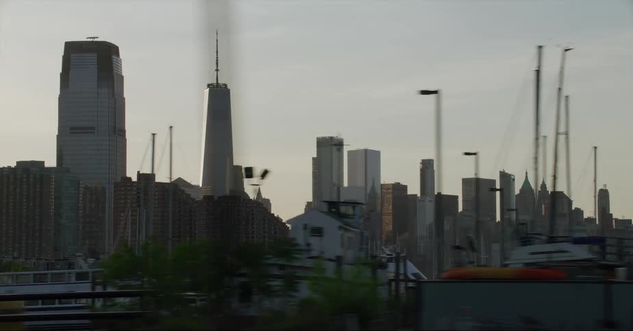 High rise buildings and skyscraper next to river with boats at dusk