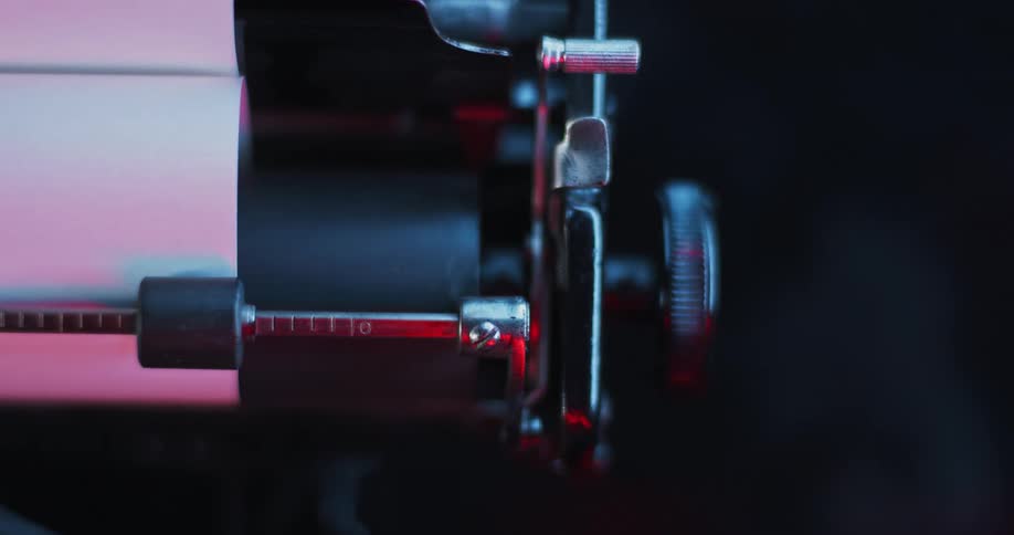 A drum turns feeding a sheet of paper through before the bar shuts