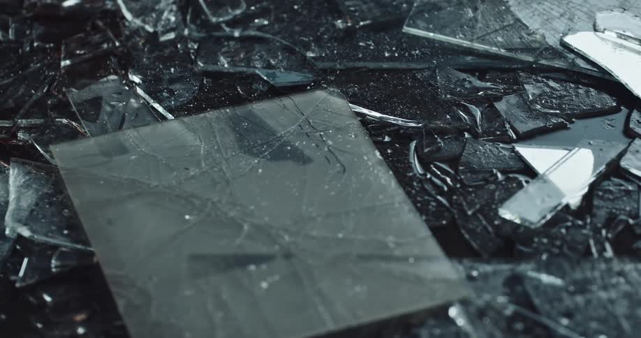 Numerous shards of broken glass are scattered all over the ground