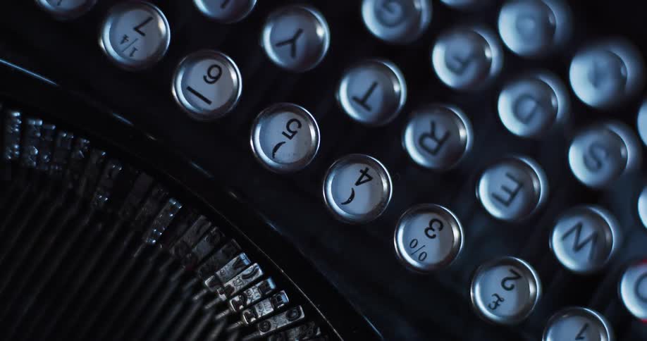 The keys and hammers of a traditional mechanical typewriter can be seen in the darkened location