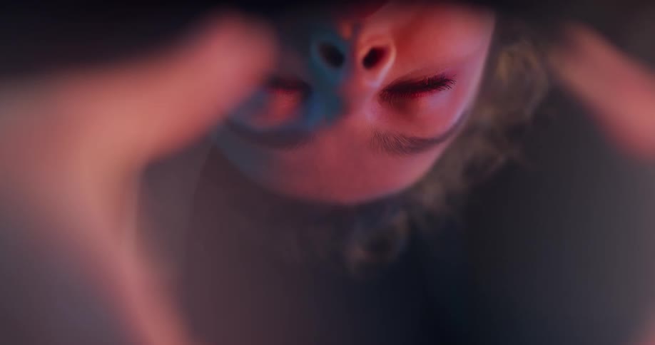The face of a woman looking down as she closes her eyes
