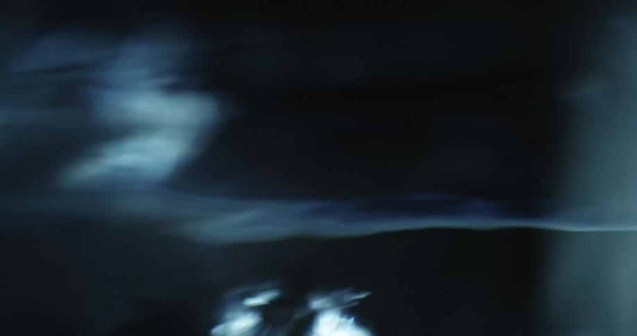 Close up of tiny air bubbles rising to the water surface on a dark environment