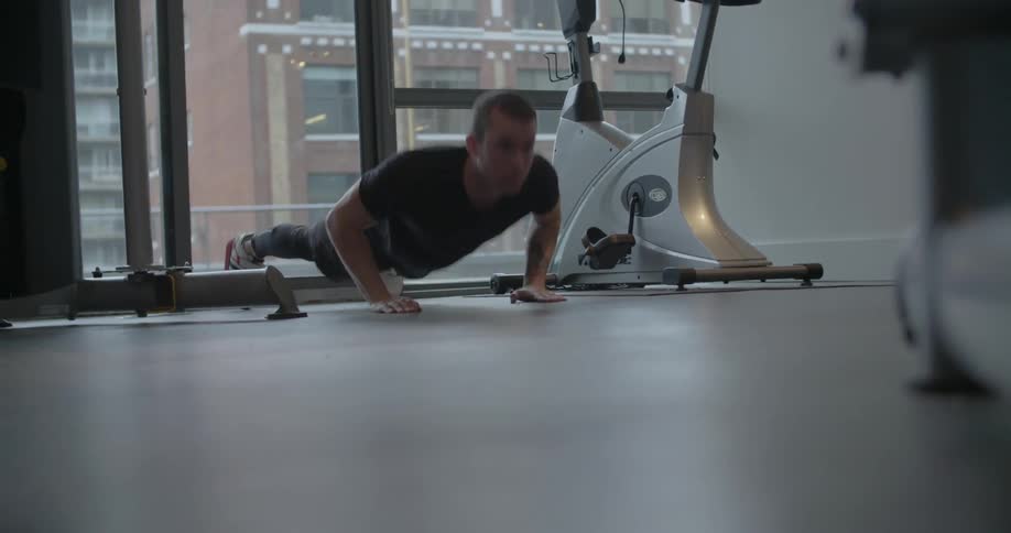 A man does push-ups in a gym