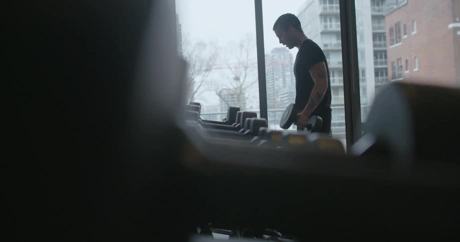 A man lifts weights at a gym