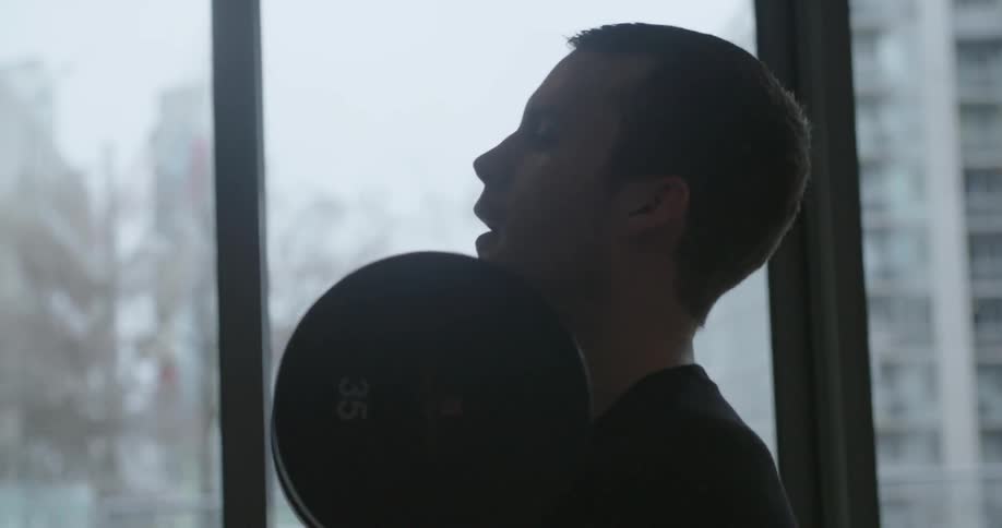 A man lifts weights at a gym