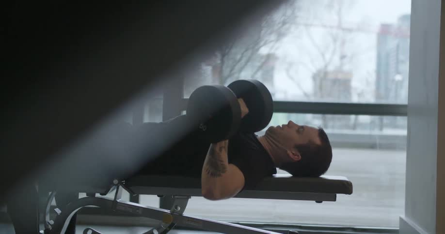 A man lifts weights at the gym