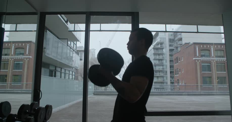 A man lifts weights in a gym