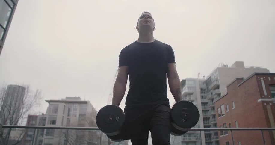 A man is walking holding barbells