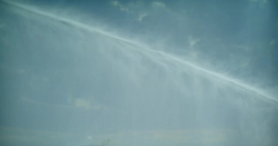 Close shot of a water jet against a blue sky