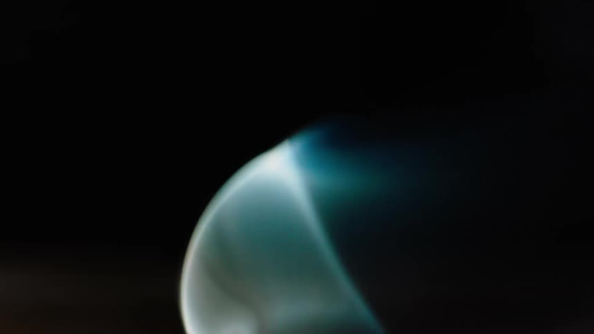 Smoke rises in a dark room