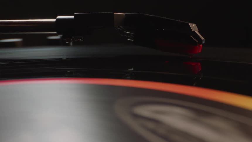 Record player arm plays record turning on turntable