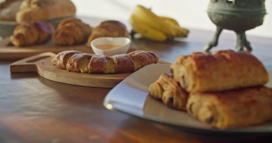 Baked goods on cutting boards and serving platters laid out on a wooden table