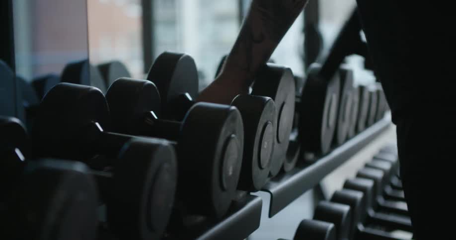 Person putting weights back on a weight rack
