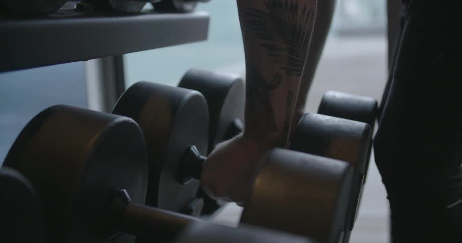 Man picks up weights in a gym