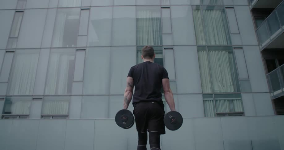A man is carrying weights outside