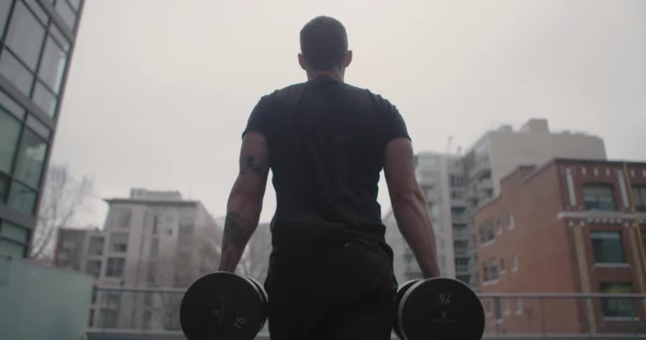 A man is carrying heavy weights outside