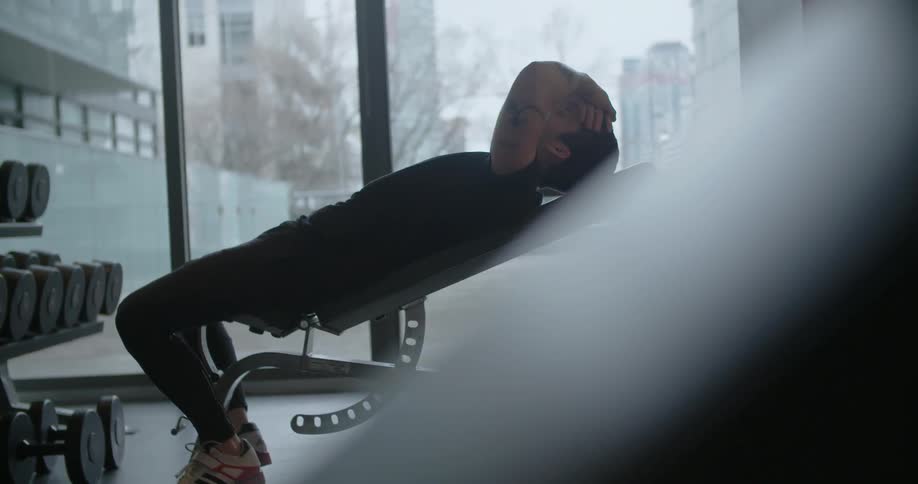 A man leans back on an exercise machine