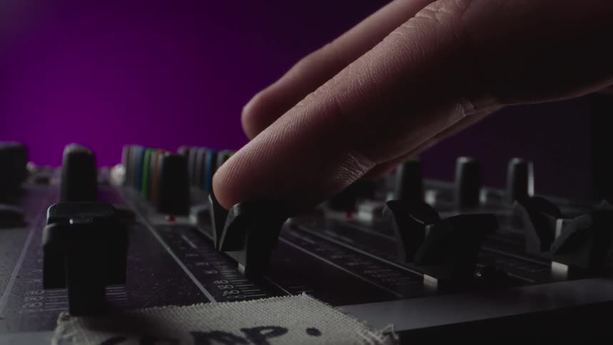 Camera tracks finger raising a slider on an amp or mixer