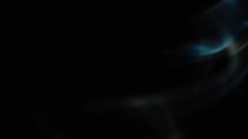 Wisps of light blue and white smoke rise in the darkness