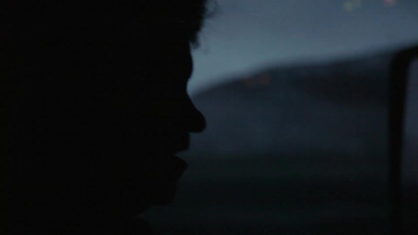 Silhouette of a person at night nodding their head