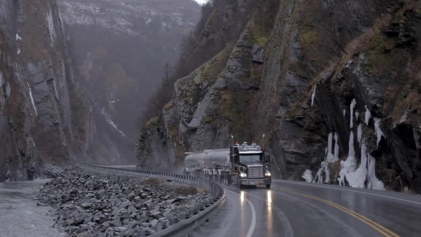 A truck drives down an icy road