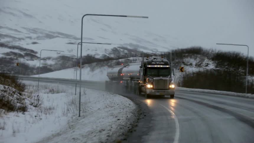 A truck drives down an icy road