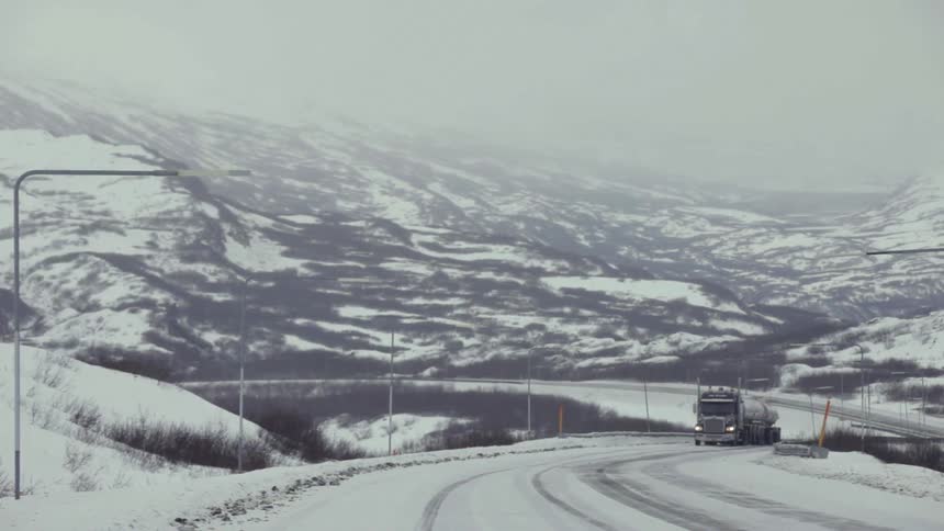 A truck drives on an icy road