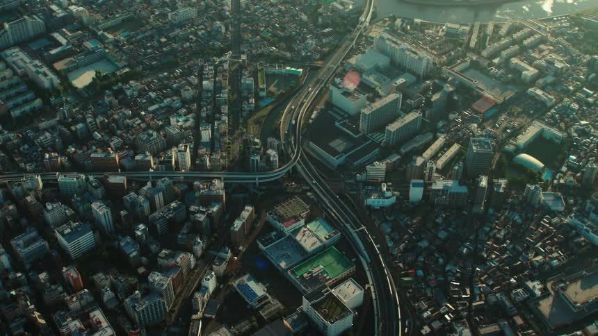 Traffic flows over elevated highways and across bridges in city penetrated by multiple waterways
