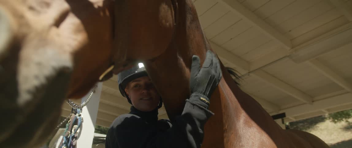 A woman pats her horse