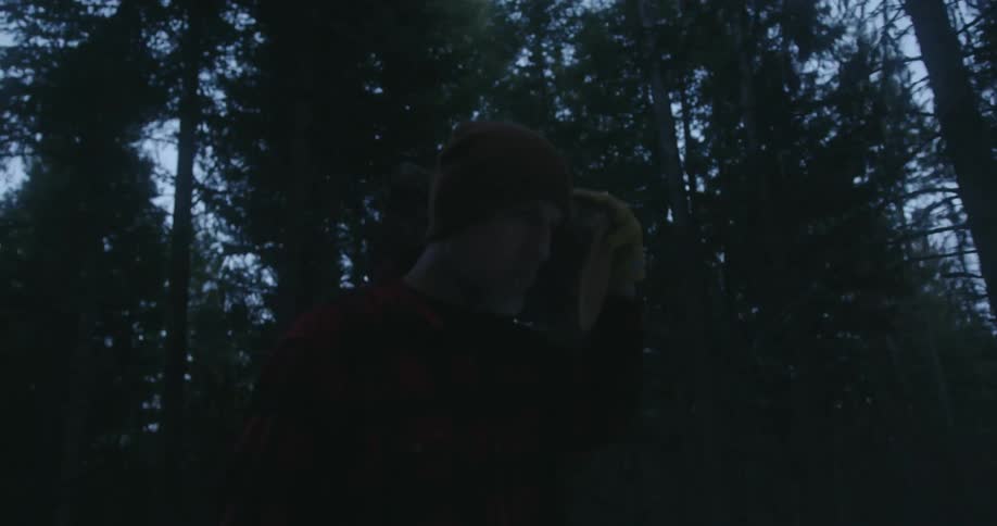 A man carries a chainsaw through the forest