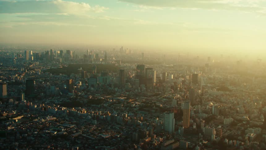 An aerial view of buildings and skyscrapers in a city at sunrise