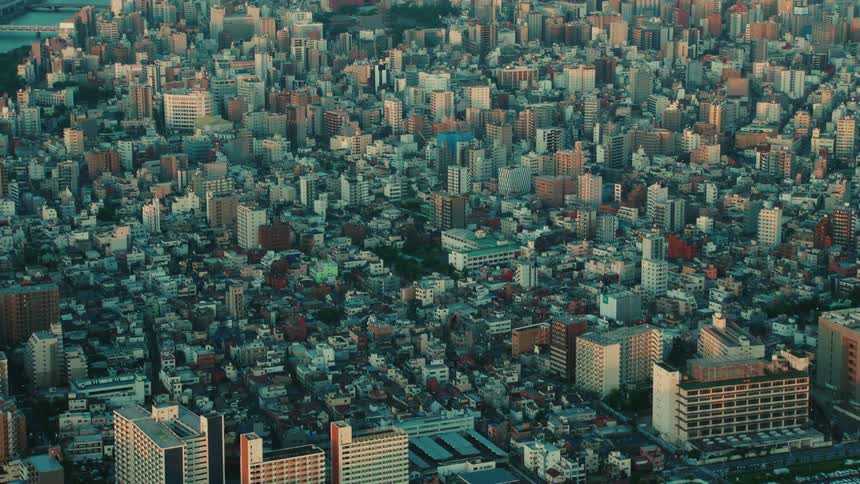 Aerial view of apartment buildings and high rise buildings next to river and bridge in the city