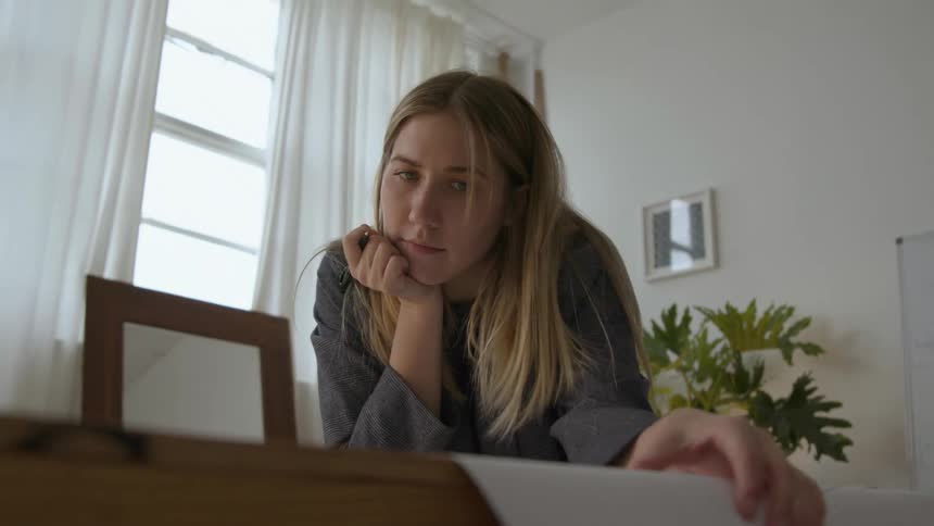 A view of a woman sketching on paper