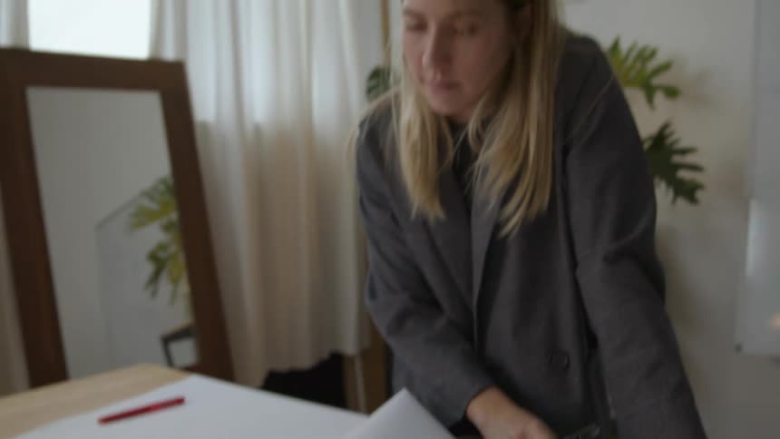 An architect is sketching on blueprints