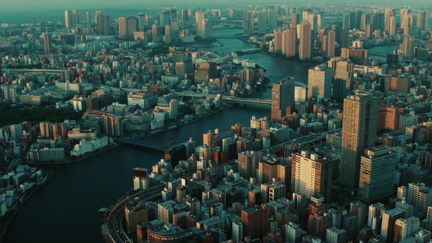 An aerial view of a river flowing through a large city with skyscrapers