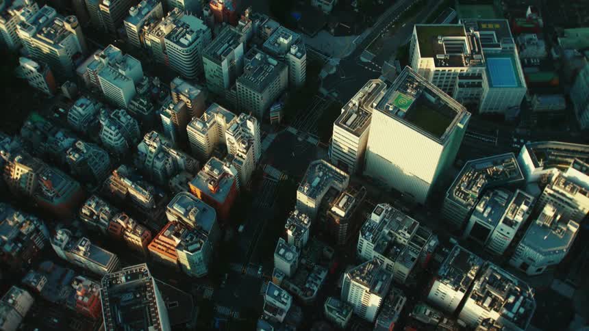 Aerial view above buildings and skyscrapers downtown as traffic moves on the street